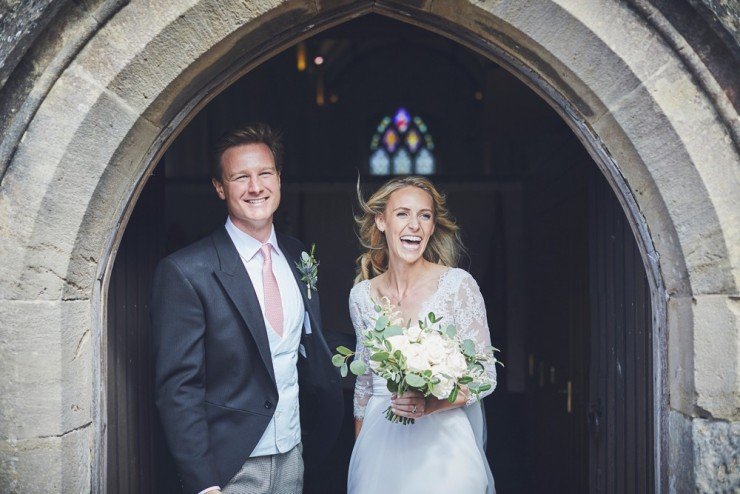 bride and groom laughing as they come out of the church at a south hams wedding in devon