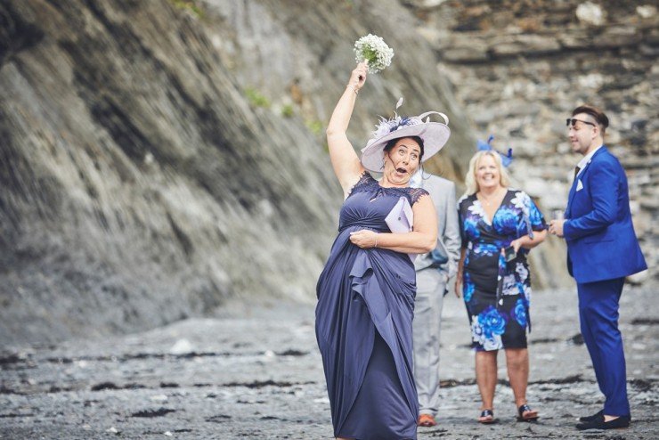 documentary wedding photography of guest laughing at Tunnels Beaches in devon