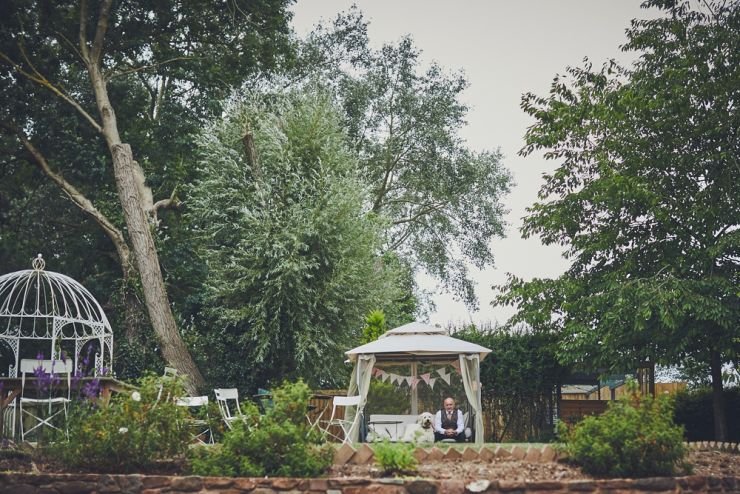 father of bride and his dog sat in his garden 