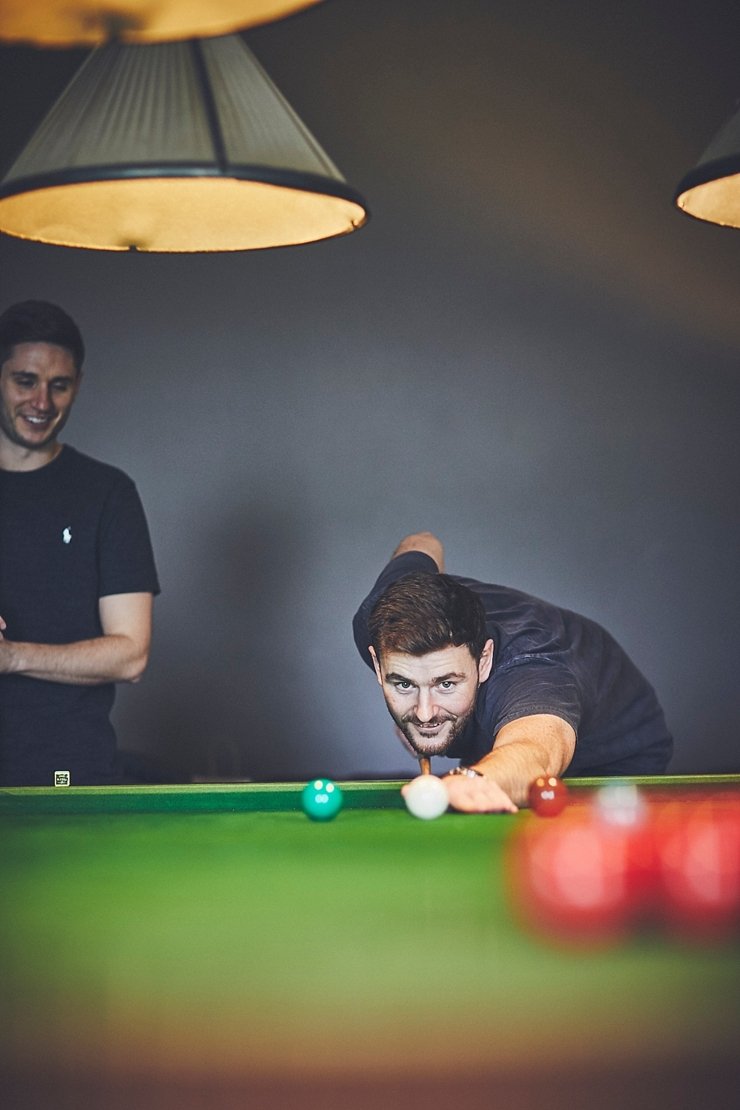 Groom playing billiards before small wedding at Rockbeare manor Devon