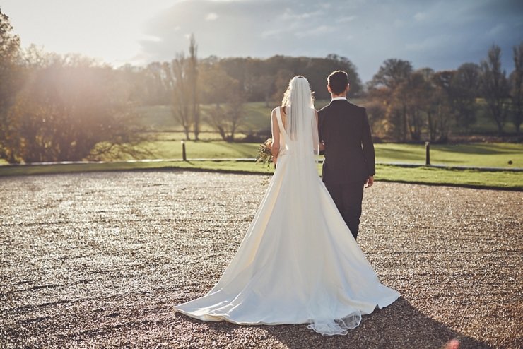 portrait of bride and groom walking at small winter wedding at Rockbeare manor in Devon