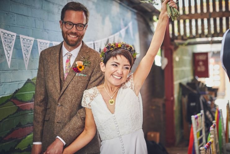 bride and groom making their entrance cheering at West Town Farm wedding in devon