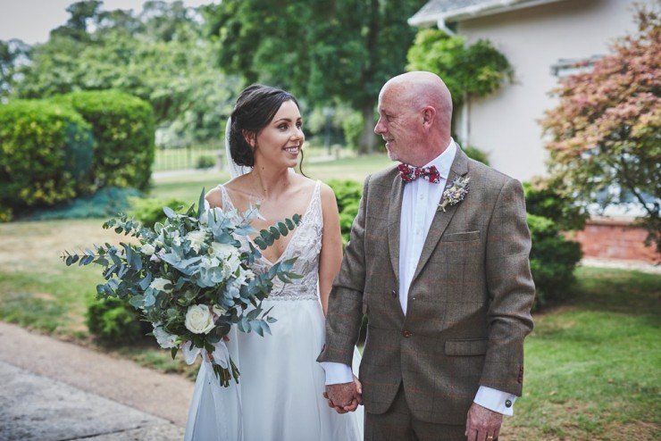 dad looking at daughter bride to be from wedding at Upton barn in Devon