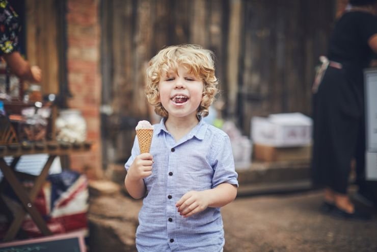 boy eating ice-cream at a wedding at West Town Farm barn wedding photography devon