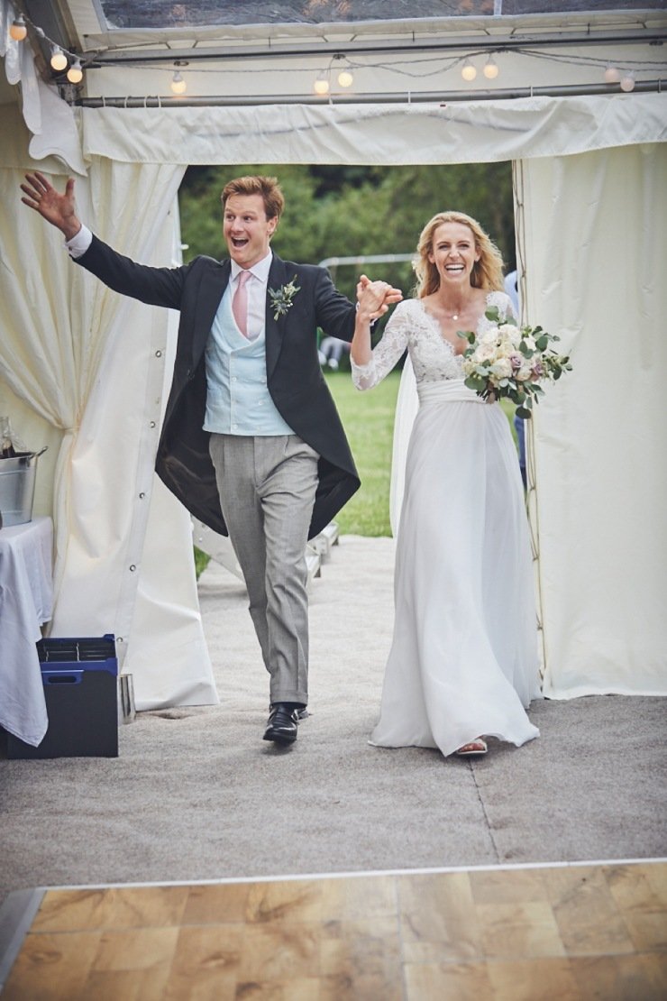 relaxed wedding photography if bride and groom entrance to marquee in Devon
