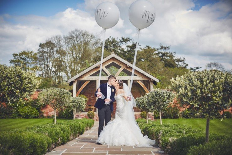 relaxed wedding photography of bride and groom with balloons at upton barn and walled garden devon
