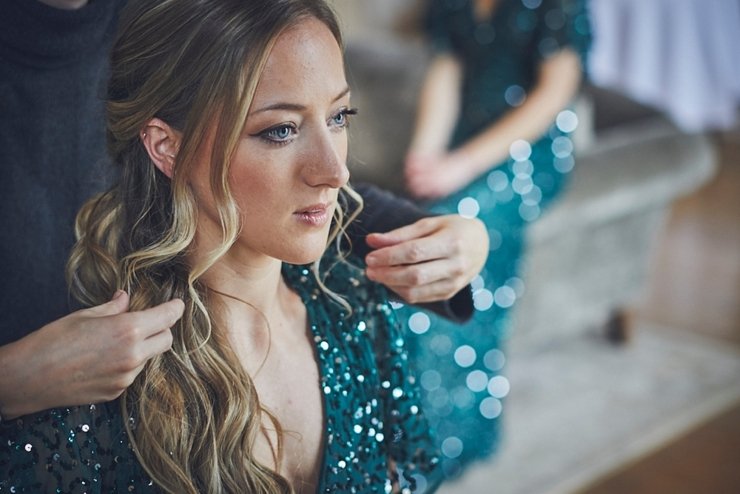 beautiful bridemaid in green sequinned gown has hair done at a small wedding at Rockbeare Manor