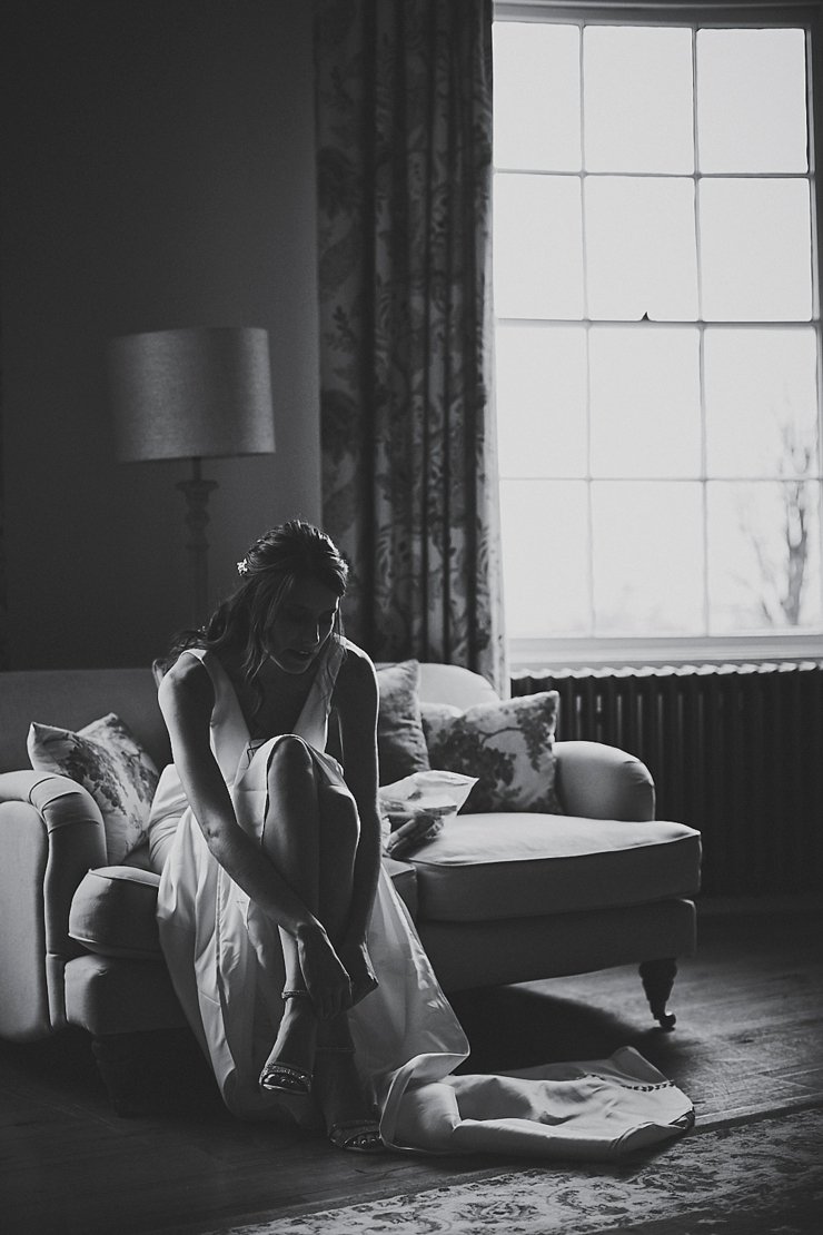 bride doing up her wedding shoes at small devon wedding