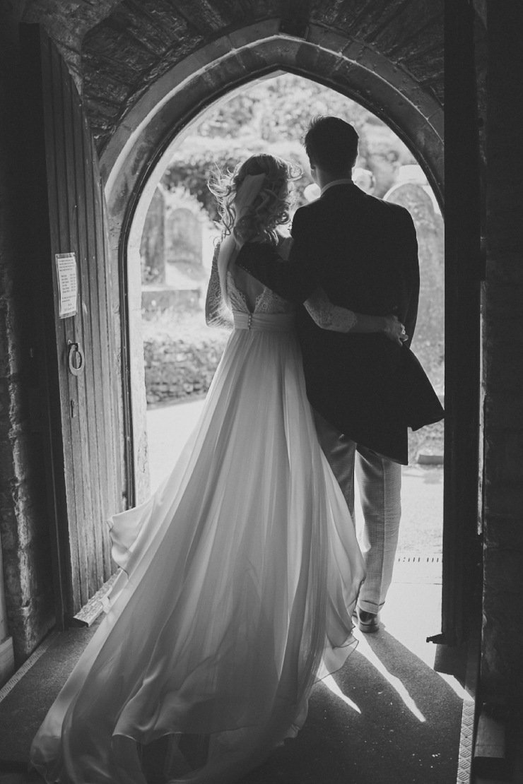 bride and groom in entrance of church in Devon