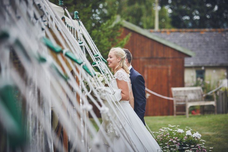 bride and groom walking into marquee happily at Somerset wedding