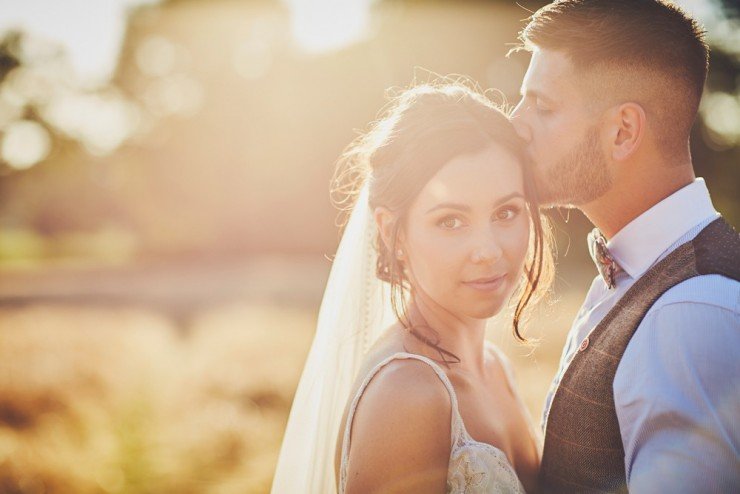 portrait bride and groom in field of corn or wheat at sunset at Upton Barn and Walled Garden in Devon