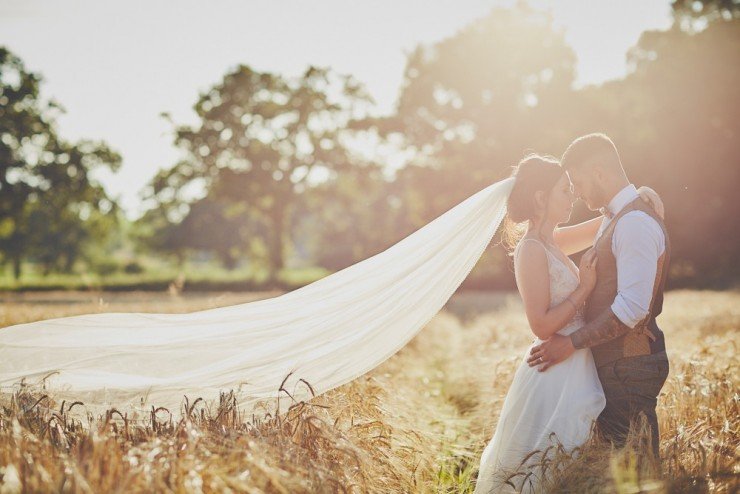 portrait bride and groom in field of corn or wheat at sunset at Upton Barn and Walled Garden in Devon