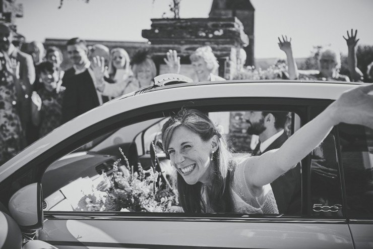 reportage photography bride waving out car window at South Hams wedding