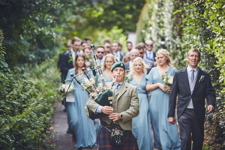 candid wedding photography of bag pipe player at devon wedding