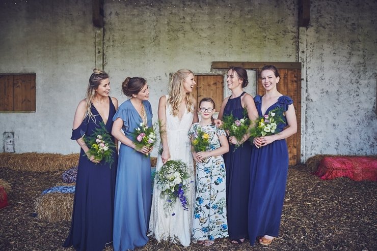 happy bridesmaids all in different blue dresses at eco wedding in devon