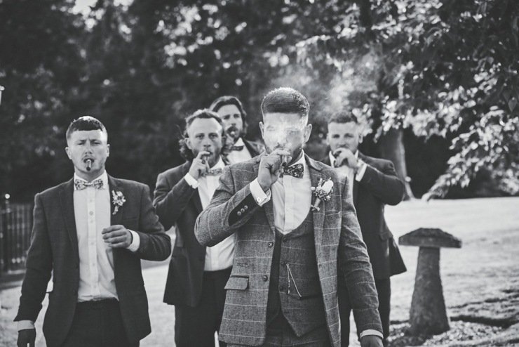 groom and ushers smiling cigars at Upton Barn and walled garden Devon