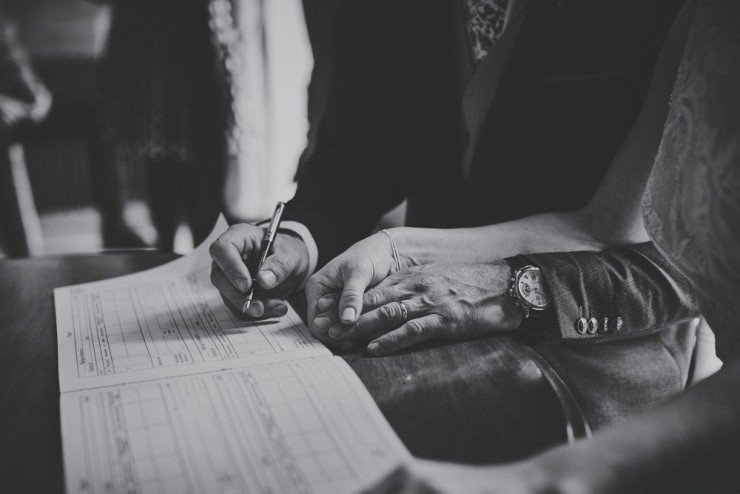 documentary photography of a hand holding signing register at a wedding at Rockbeare Manor near Exeter in Devon 