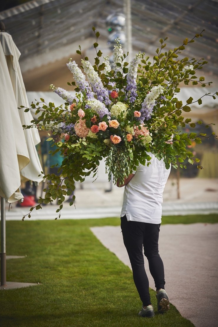 florist carrying pedestal flowers at Devon wedding