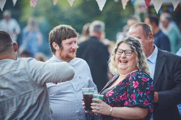 fun wedding photography of guests laughing at a Devon wedding at West Town farm