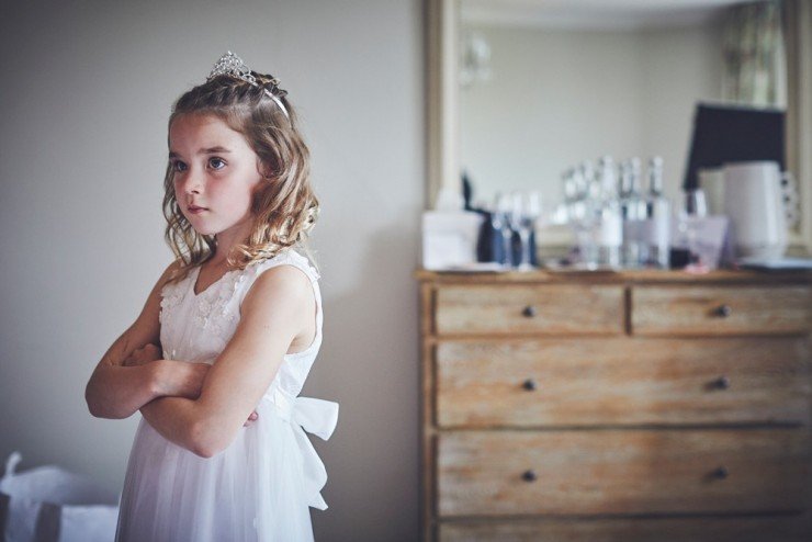 documentary photography of flower girl looking stern at a wedding at Rockbeare Manor near Exeter in Devon 